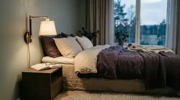 Nattlampe som lyser varmt på et nattbord