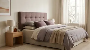 Polstret sengegavl bak en oppredd seng
